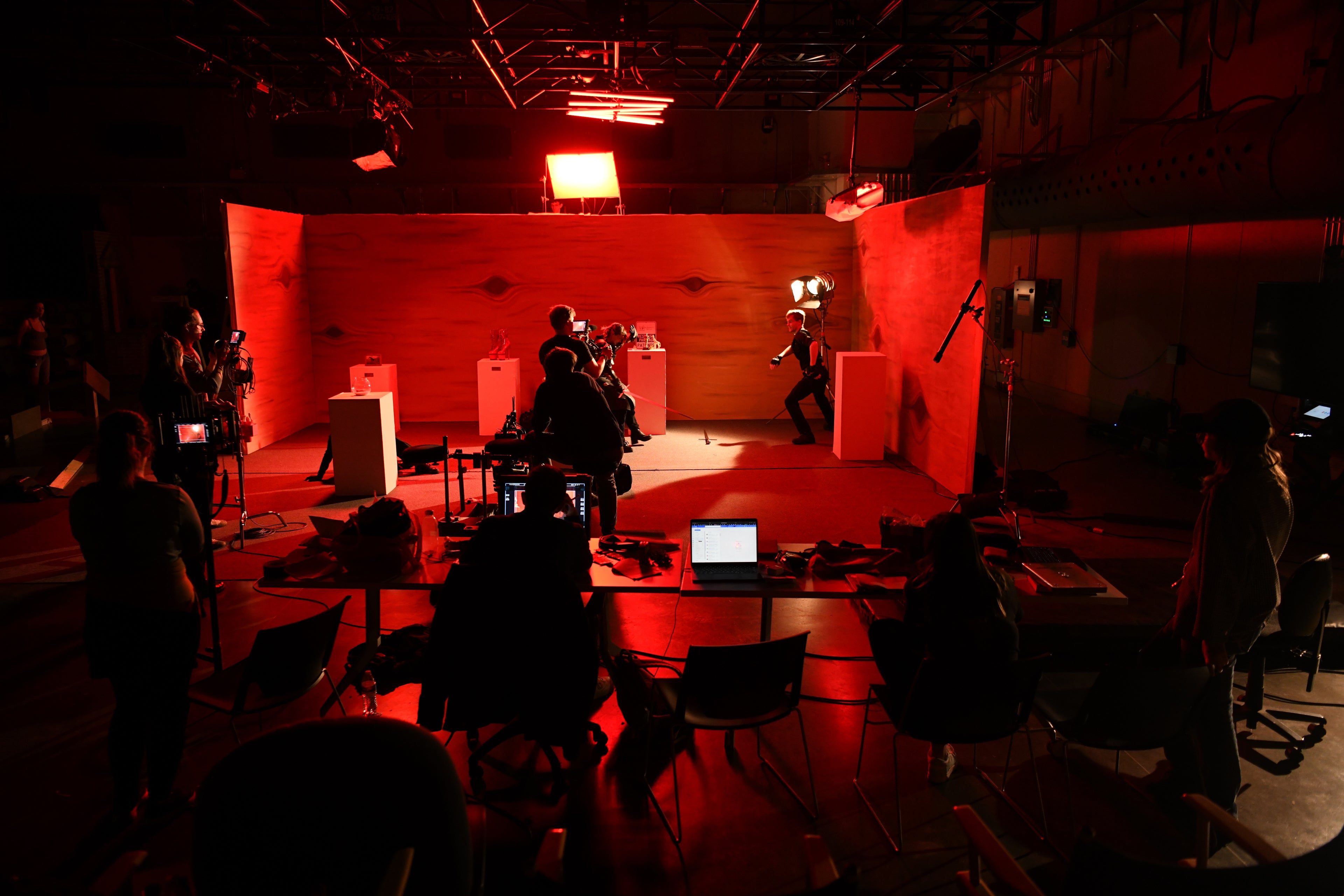 Stage with performers and audience in a dark film studio setting